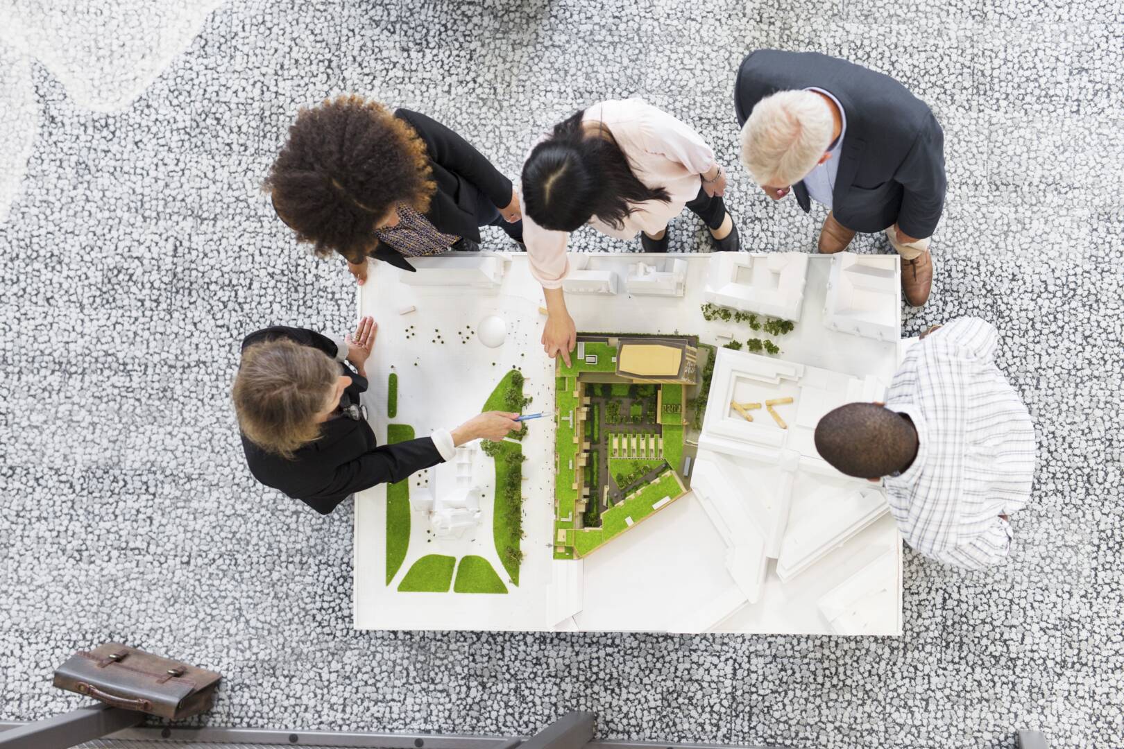 Team of professionals evaluating architectural model